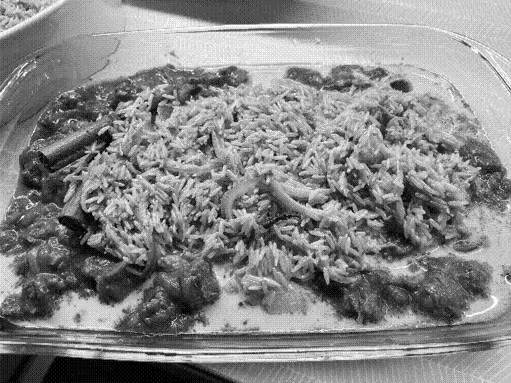 A baking dish with sauce at the bottom and rice on top.