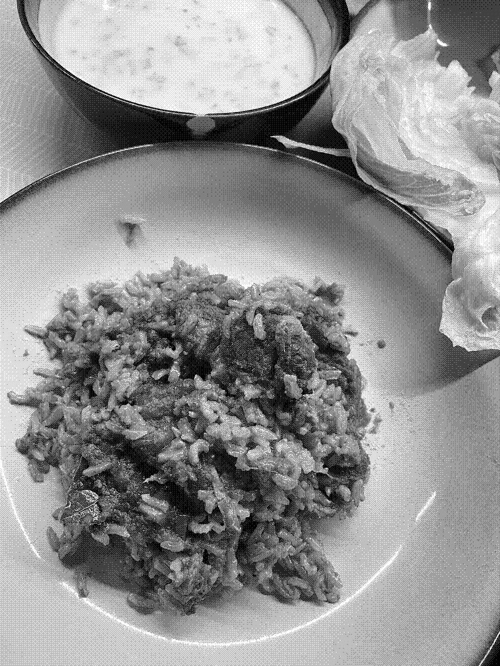 A portition of Biryani with lettuce and yoghurt 
