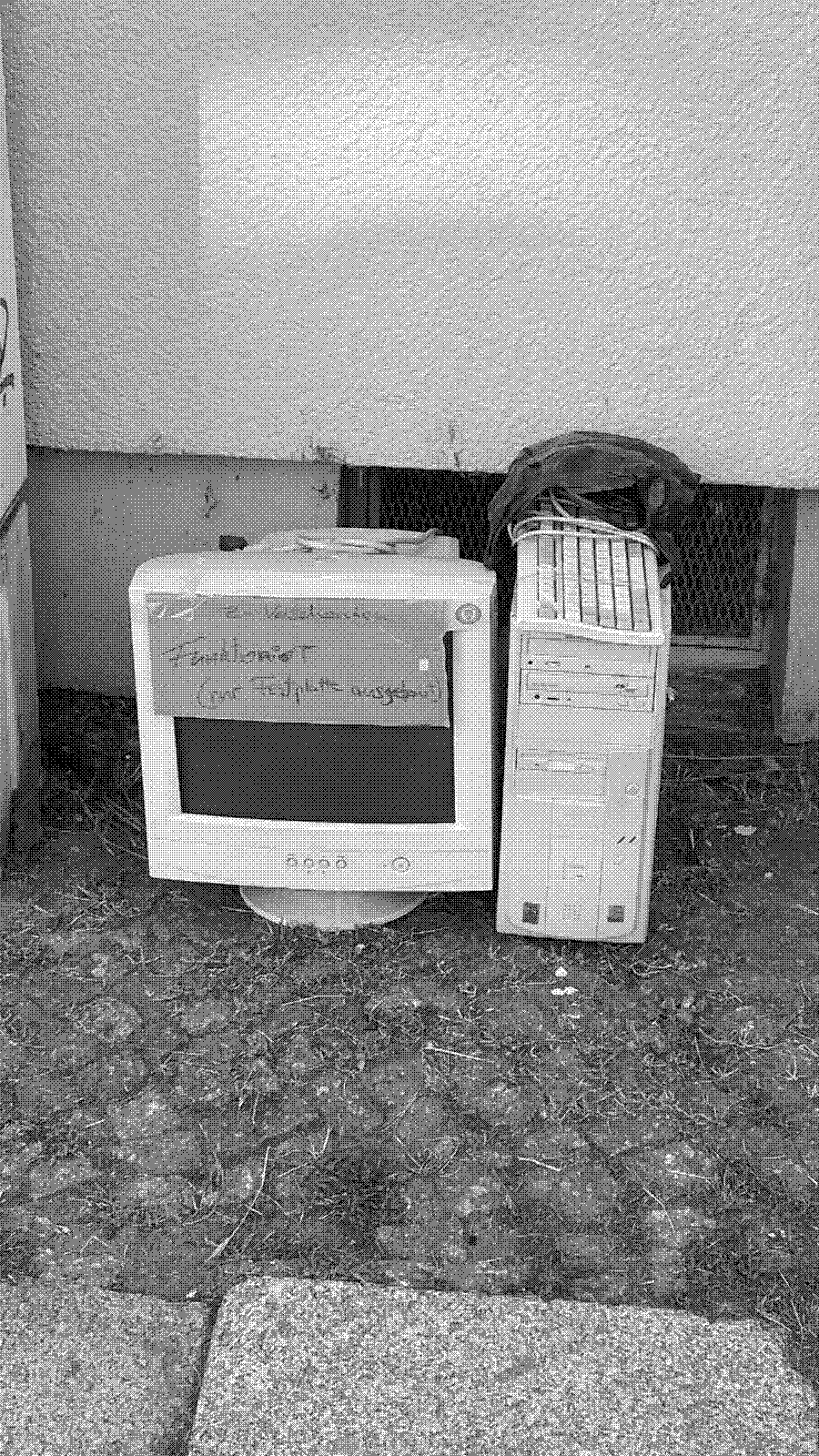 A desktop PC and CRT from the 90s era standing on the street with a sign 'to take away - works - just removed the HDD'